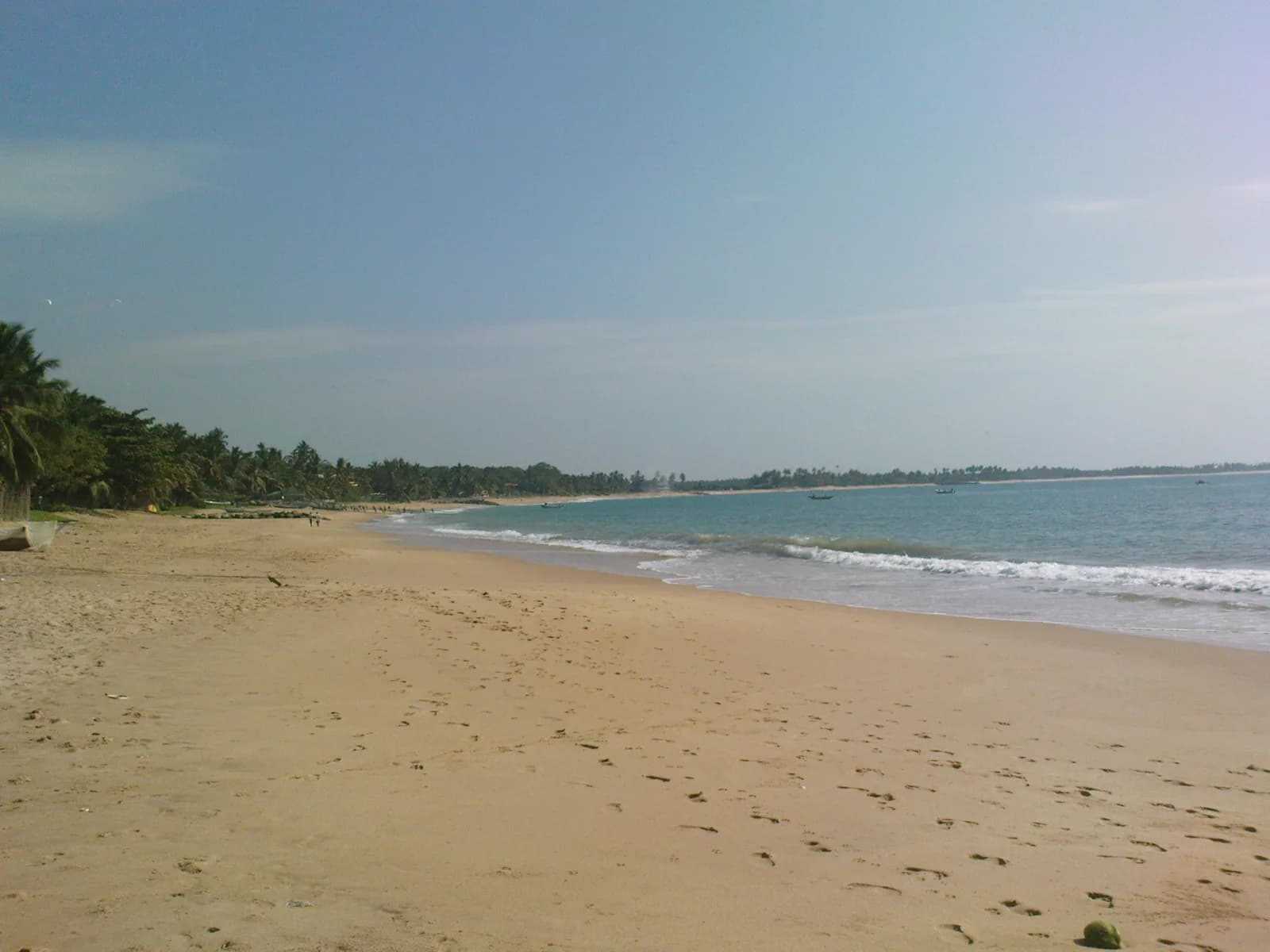 Secluded golden sand cove framed by coconut palms and rocky headlands in Tangalle Southern Sri Lanka