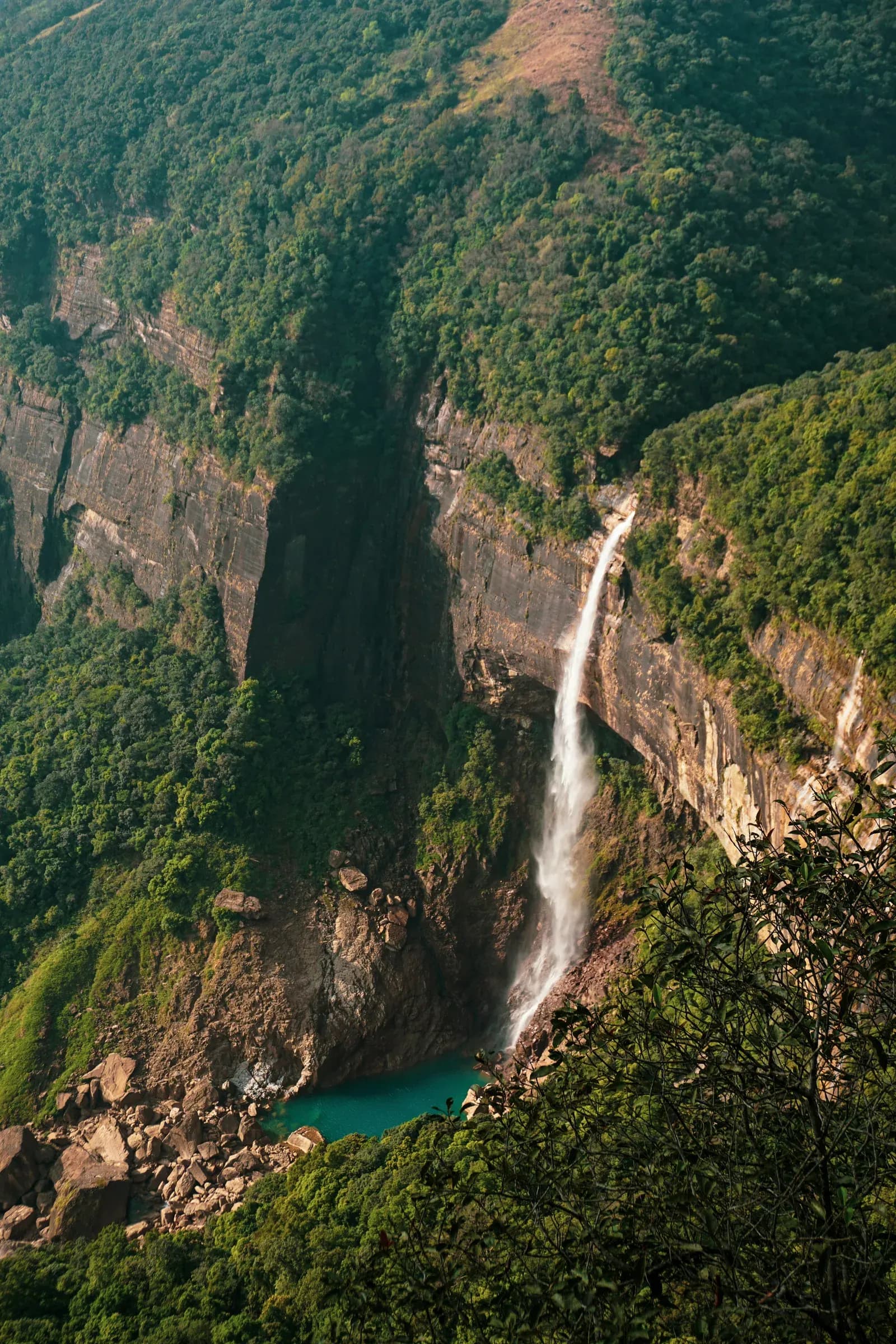 Spectacular tall waterfall tumbling down steep rock face in central highlands.